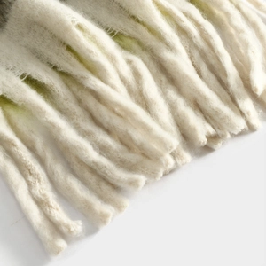 Close-up detail of soft wool blend scarf tassel fringe, cozy winter accessory texture.