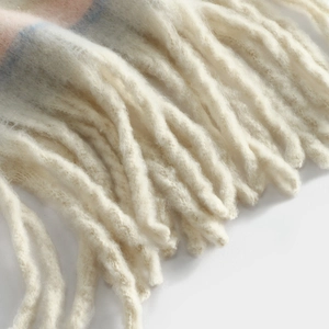 Detailed view of soft winter cashmere scarf fringe, cozy warm chunky tassel shawl texture.