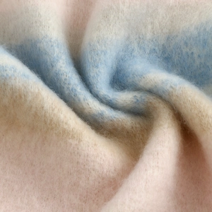 Close-up of soft cashmere-feel scarf fabric showing plush texture and pastel color gradients.