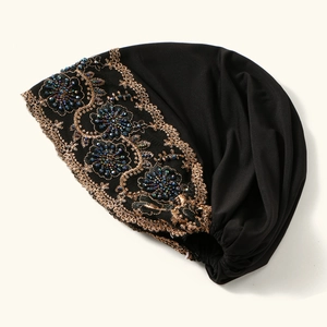 Elegant black turban hat with golden floral embroidery and blue beaded details