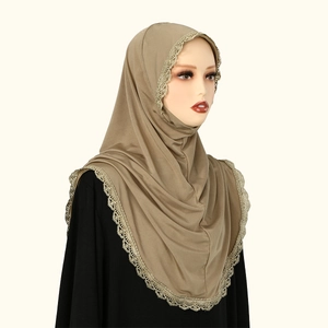 Detail of khaki chiffon hijab showing intricate golden lace embroidery and draped fabric