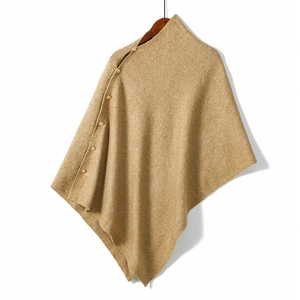 Detail of camel knit poncho with high neck and side gold buttons for winter warmth