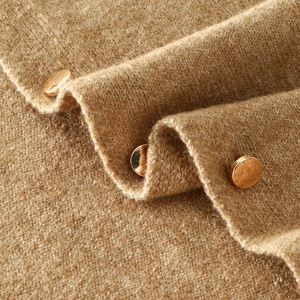Thick camel knitted shawl cape featuring elegant gold button details and premium texture