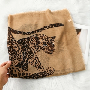 Vintage leopard print shawl scarf with fringe edges on white plush background