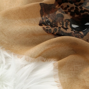 Vintage leopard print shawl with raw fringe edges on soft white plush background