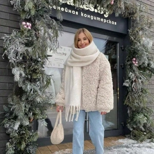 Femme portant une écharpe épaisse blanche unie avec franges aspect cachemire pour l'hiver