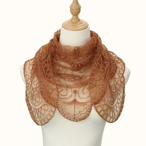 Macro shot of dark brown lace scarf with elegant swirl embroidery and scalloped edges