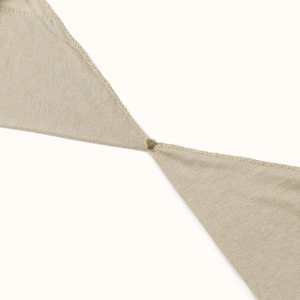 Detail shot of beige cross turban hat showing reinforced overlock stitching and knit texture