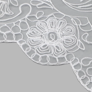 Detailed macro shot of intricate white floral embroidery on premium fine mesh fabric