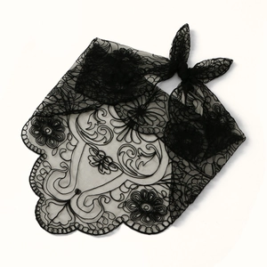 Close-up of black lace floral embroidery with scallop edges and sheer mesh texture