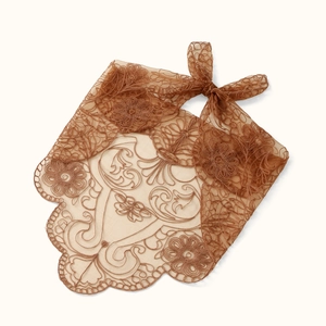 Close-up of intricate floral embroidery and scalloped lace edges on brown tulle scarf