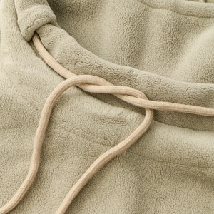 Detail of plush fleece fabric texture and matching drawstring on hooded scarf