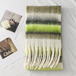 Detail of thick winter scarf with green and grey stripes and long fringe tassels