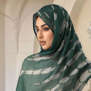 Detail of dark green ethnic hijab scarf with abstract print and soft drape texture