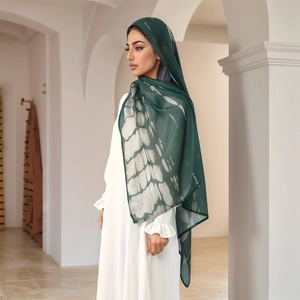 Detail of dark green printed hijab with tie-dye pattern showing elegant fabric drape