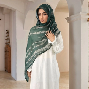 Detail of dark green ethnic hijab with white abstract print on lightweight fabric
