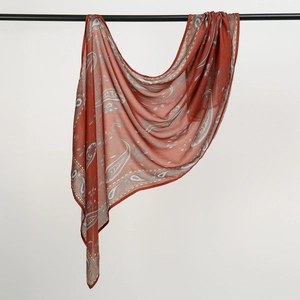 Detail view of brick red paisley cotton scarf with delicate white border pattern