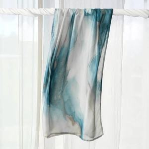 Detail showing the lightweight fabric texture and blue ink painting pattern on the headscarf