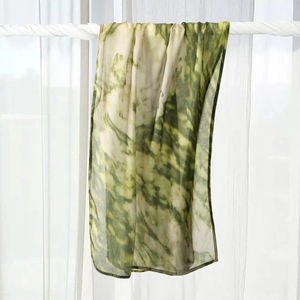 Detailed view of green tie-dye rayon scarf texture and fine rolled edge stitching