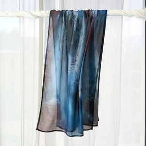 Detailed view of sheer printed headscarf with abstract blue and brown art patterns