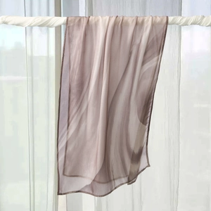 Close-up of semi-transparent silk scarf with purple wave patterns and fine rolled edges
