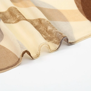 Détail d'écharpe en soie georgette avec motifs géométriques et bordures roulées fines