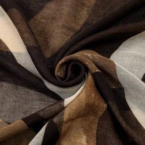 Détail d'une écharpe en georgette douce avec motif à carreaux géométrique marron et kaki