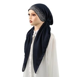 Detail of silver rhinestones on the dark blue cotton hijab worn by a mannequin