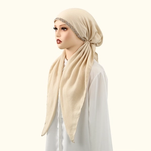 Close-up of sparkling rhinestone trim on elegant beige cotton hijab headscarf