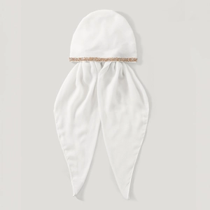 Detail of white chiffon turban cap showing gold sequin trim and long flowing ties