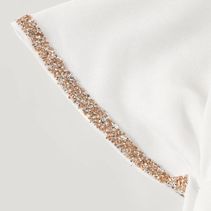 Detail of white cotton linen headscarf with sparkling rhinestone trim and soft fabric texture