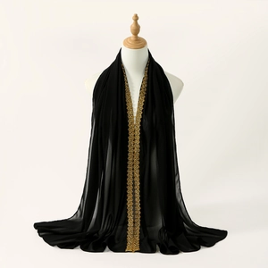 Close-up of black chiffon scarf featuring delicate golden lace flower embroidery details
