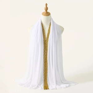 Detail of white chiffon scarf with intricate golden floral lace embroidery on a mannequin