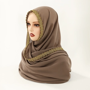 Detailed close-up of dark brown chiffon hijab with intricate gold crochet lace trim
