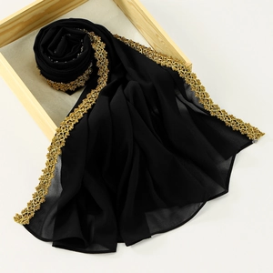 Detailed macro view of black chiffon shawl with golden sequin embroidery edges