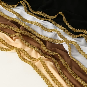 Detail of four chiffon fabrics in black, white, brown and beige with golden lace edges
