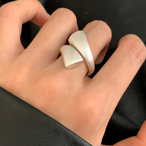 Minimalist brushed silver open ring with geometric design worn on a finger