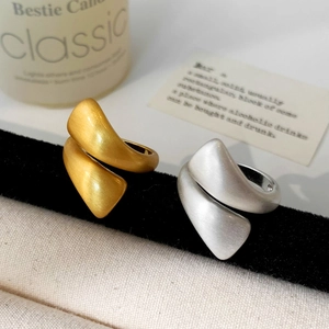 Minimalist brushed metal open rings in gold and silver finish with organic twisted design