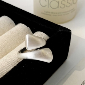 Close-up of matte brushed silver ring with asymmetric geometric design in a jewelry box