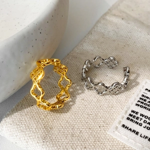 Set of gold and silver hollow geometric open rings on a beige linen bag background