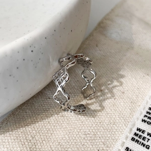 Macro view of adjustable silver hollow floral ring featuring clover cut-out details
