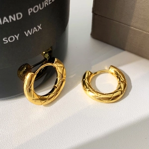 Detail of gold quilted hoop earrings featuring premium textured metal finish and 18k shine