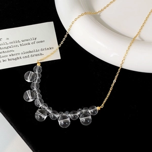 Detailed view of OT buckle glass bead necklace with transparent cartoon charms on black velvet