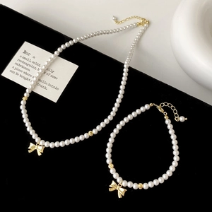 Parure de collier et bracelet en perles avec nuds dorés élégants et fermoir réglable