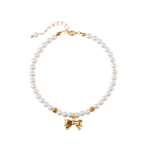 Détail du bracelet en perles avec pendentif nœud doré et fermoir mousqueton ajustable