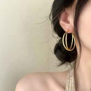 Chic triple-layered geometric gold hoop earrings worn by a model for a luxury daily look