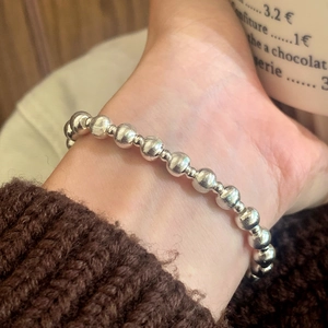Brushed silver ball bracelet for women shown in a stylish lifestyle wrist shot