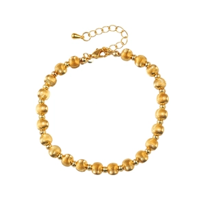 Close-up of gold beaded bracelet with brushed texture, lobster clasp and extension chain