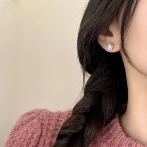 Boucles d'oreilles tournesol en argent avec zircons brillants portées par un mannequin