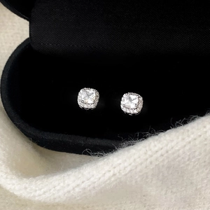 Vue rapprochée de boucles d'oreilles carrées en zircone dans un écrin en velours noir